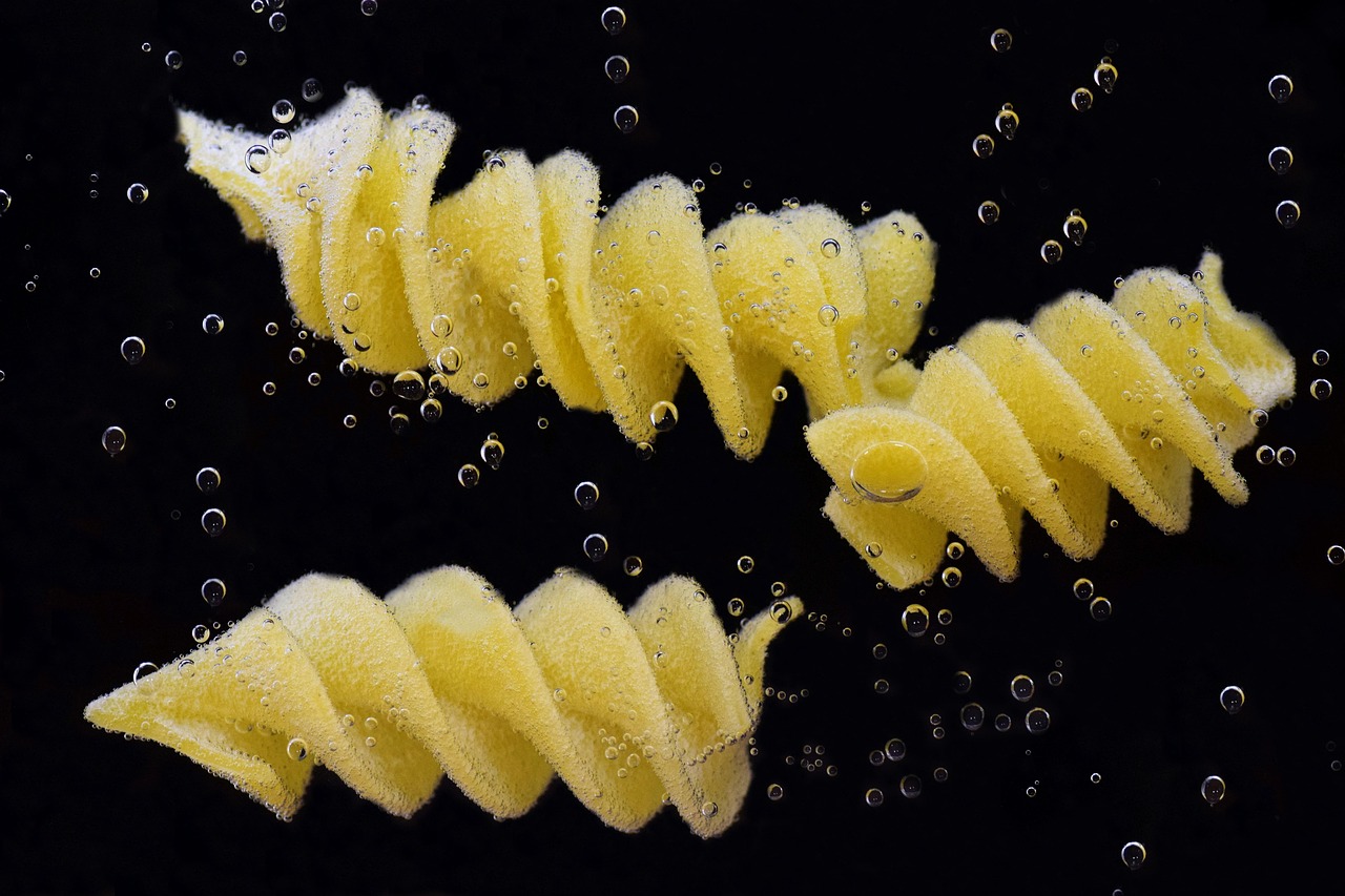 Acqua di cottura della pasta versata in un vaso con piante verdi.