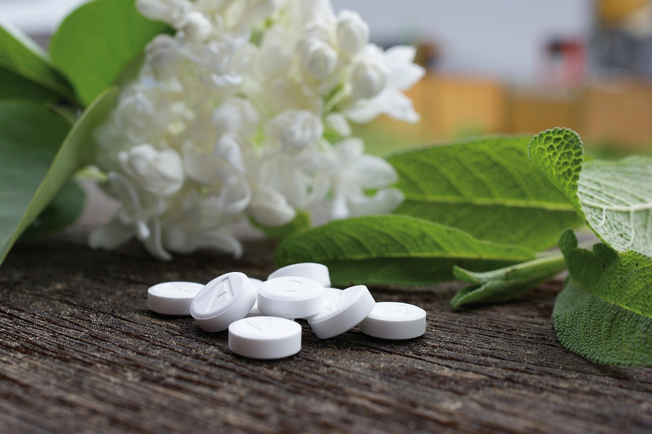 Un vaso di piante con acqua e compresse di aspirina galleggianti, simbolo di esperimenti botanici.