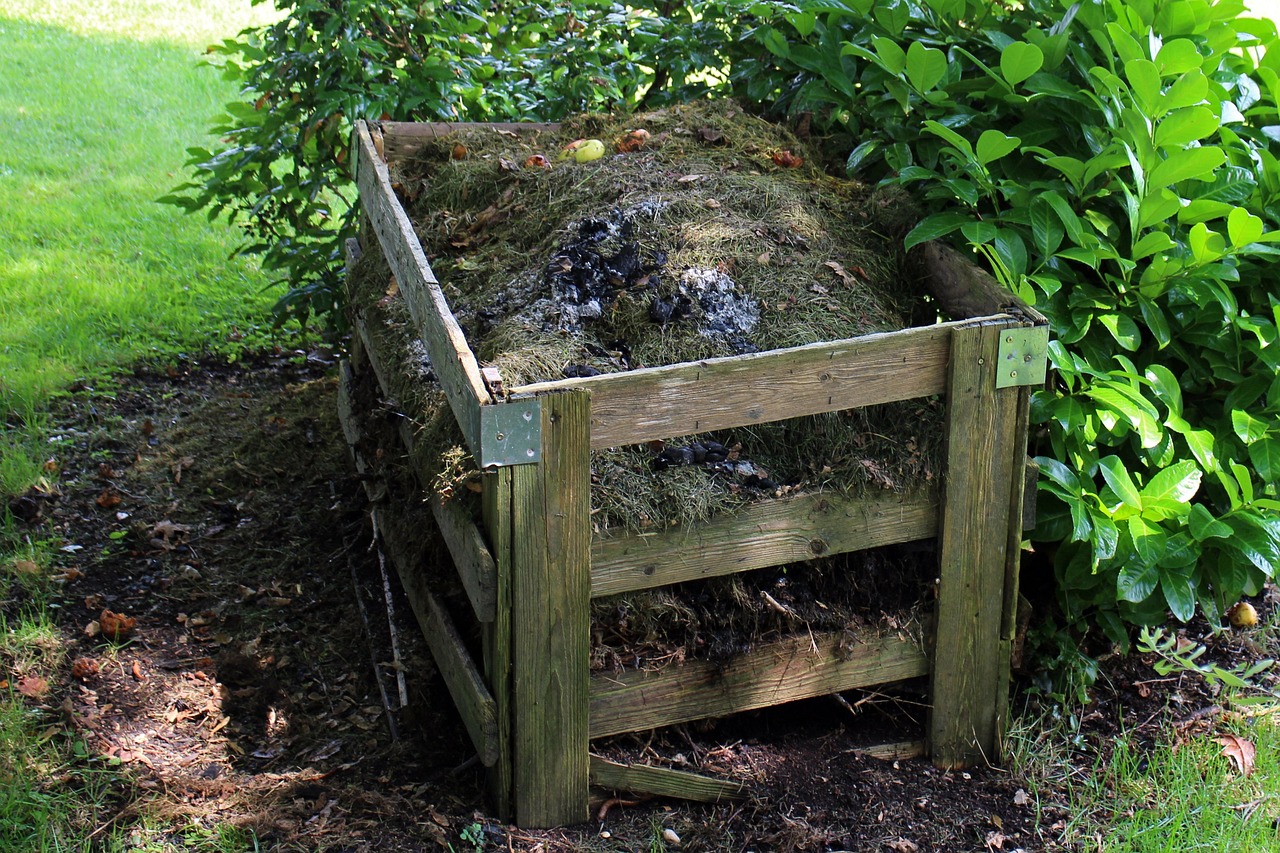 Immagine di un compostaggio domestico con materiali naturali e attrezzi per fertilizzare il giardino.