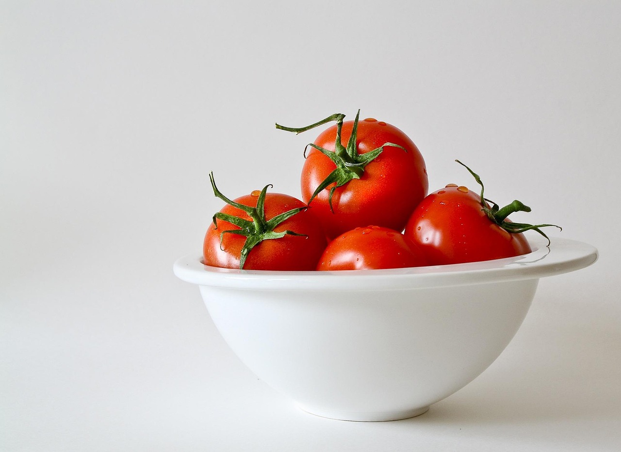 Cane curioso che osserva un pomodoro su un tavolo, in un contesto di discussione veterinaria.